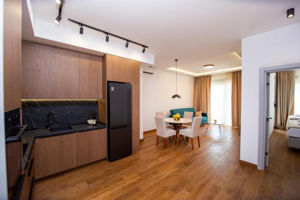 a kitchen and a living room with a table at Lastva Cozy apartment in Prijevor