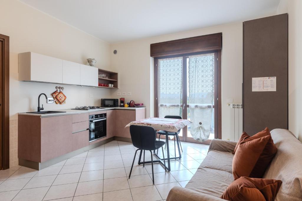 a kitchen and living room with a couch and a table at Turin Airport apt B in Leinì
