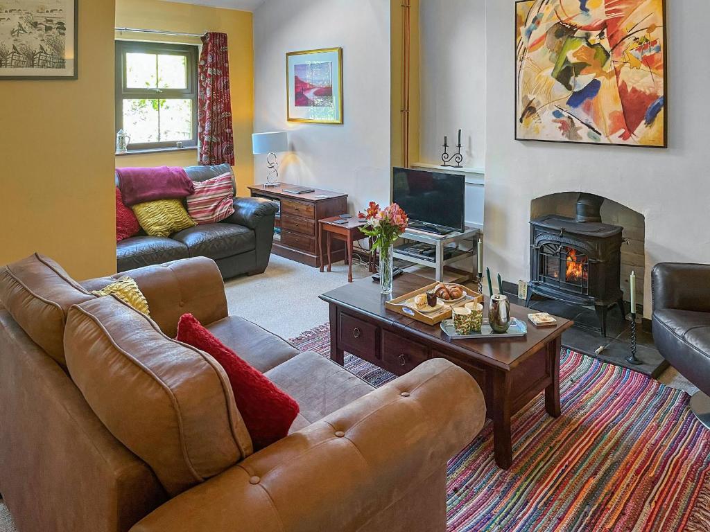 a living room with a couch and a fireplace at Enginemans Cottage in Bishop Auckland