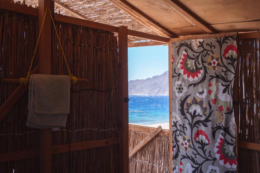 a room with a view of the ocean and a towel at Eden Camp Abu Galum in Dahab