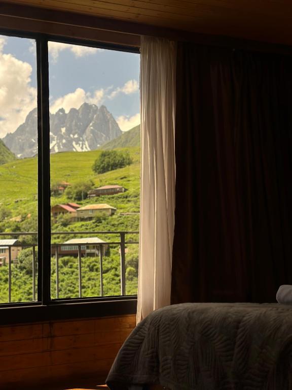 a bedroom with a window with a view of a mountain at Aisi in Jut'a