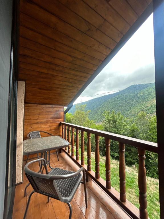 a balcony with chairs and a table and a view at Forest Edge in Borjomi