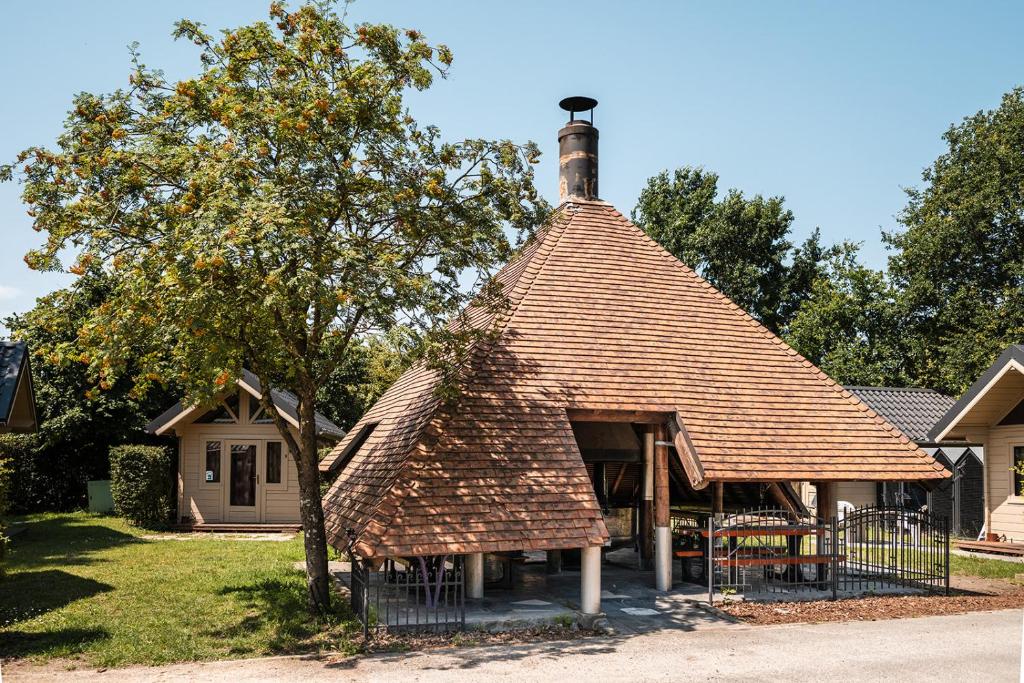 ein kleines Haus mit einem Schornstein auf dem Dach in der Unterkunft Camping Groenpark in Zele