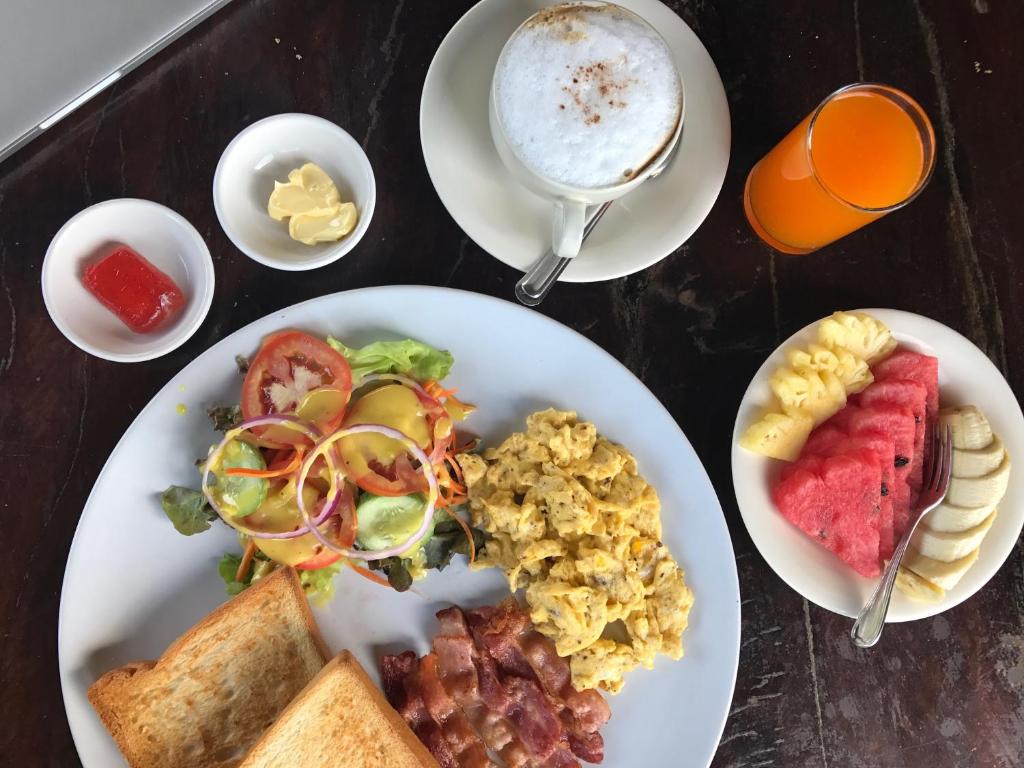 una mesa con platos de comida y una taza de café en Friendly Koh Jum, en Ko Jum