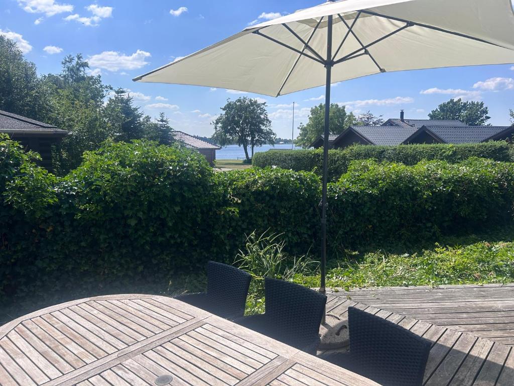 a white umbrella sitting on a table with chairs at Herning, Sunds Lake Beautiful View & Spa 105 m2 in Sunds