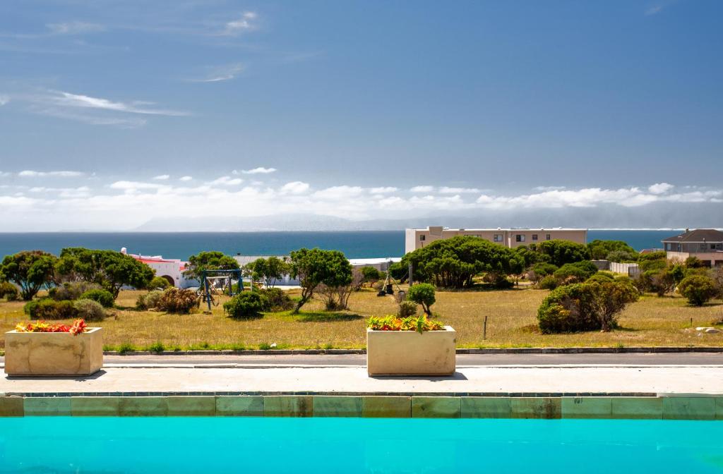 two planters on a sidewalk with a view of the ocean at Benguela in Gansbaai
