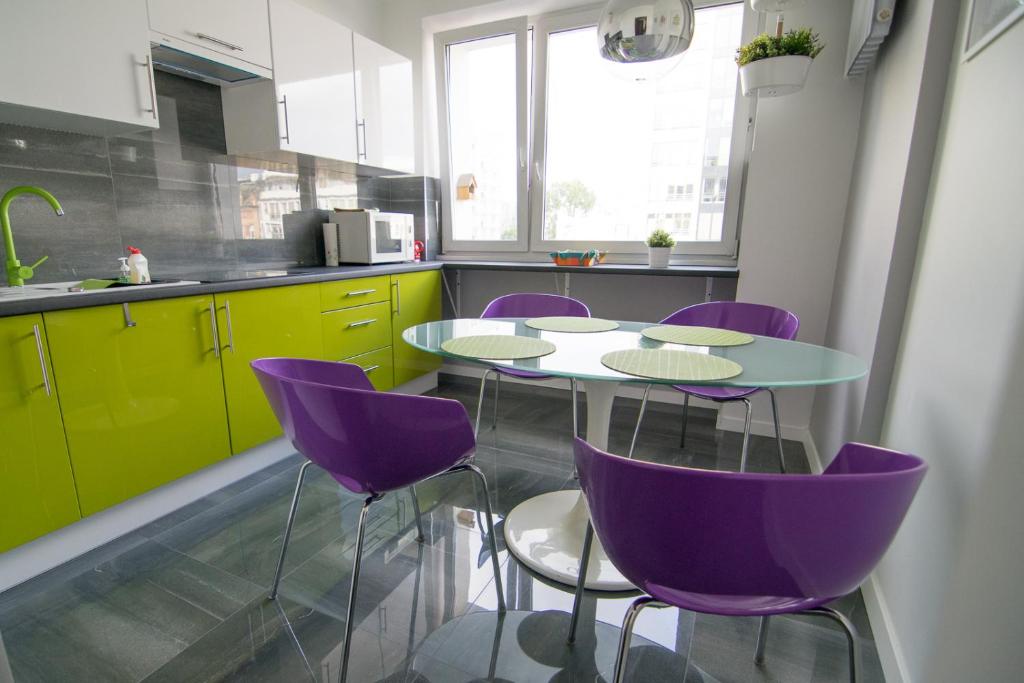 ワルシャワにあるBright Apartment Hozaのキッチン(紫の椅子、テーブル付)