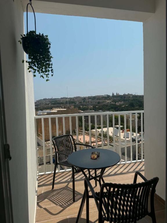 a patio with a table and chairs on a balcony at Top Floor Penthouse with Valletta Views & Terrace in Gwardamanġa