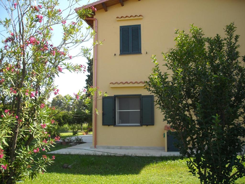 een geel huis met zwarte luiken erop bij Fra il Verde e l'Azzurro in Oristano