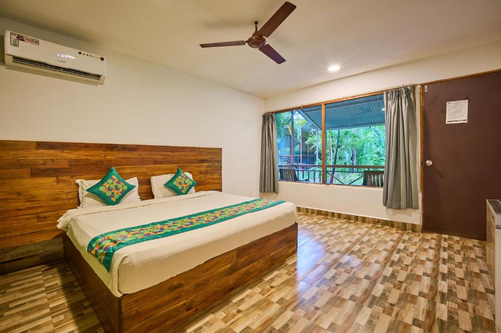 a bedroom with a bed and a large window at Treebo Lands End Beach Resort - 100m From Morjim Beach in Morjim