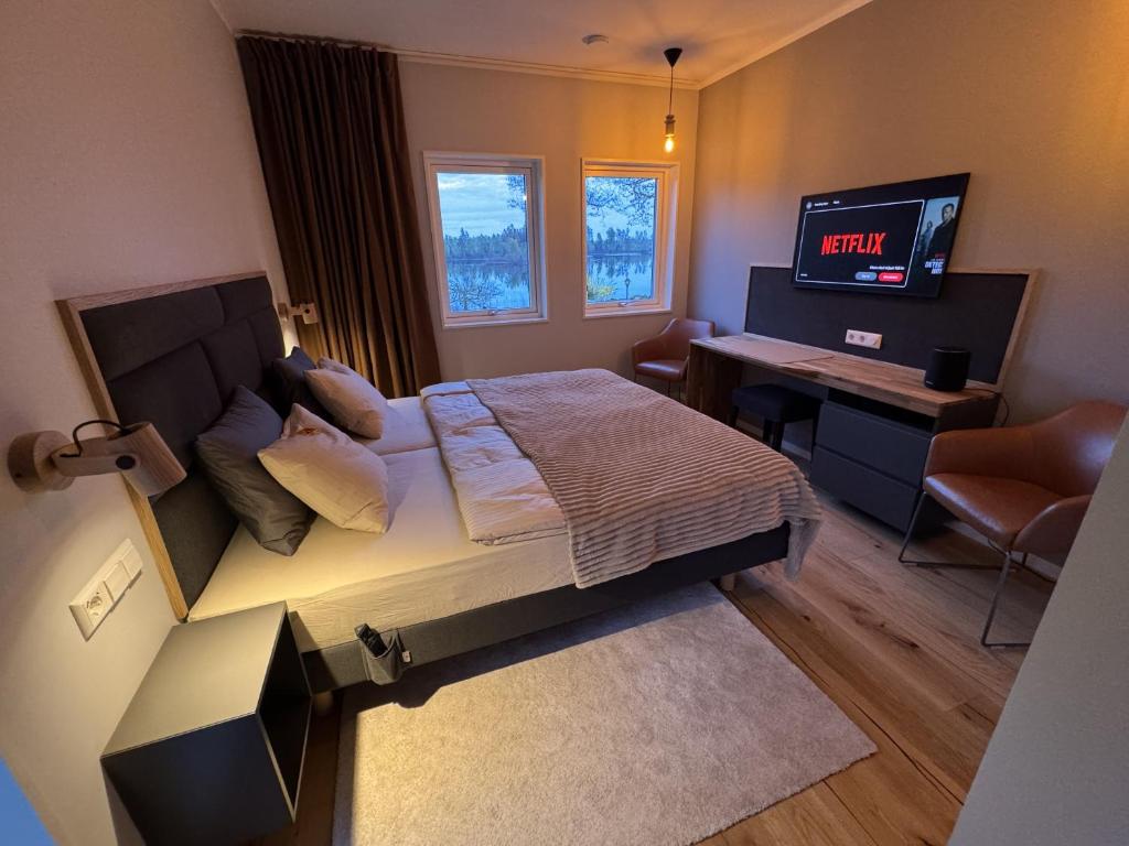 a bedroom with a bed and a desk and a television at Lake House Rågeboda in Södra Rågeboda