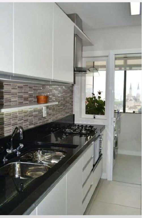 a white kitchen with a sink and a stove at AbaHome Paiva in Cabo de Santo Agostinho