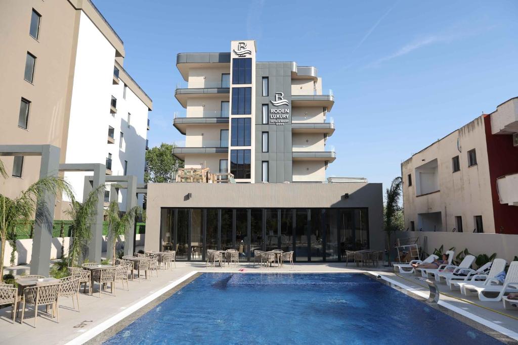 a hotel with a swimming pool in front of a building at Hotel Roden in Golem