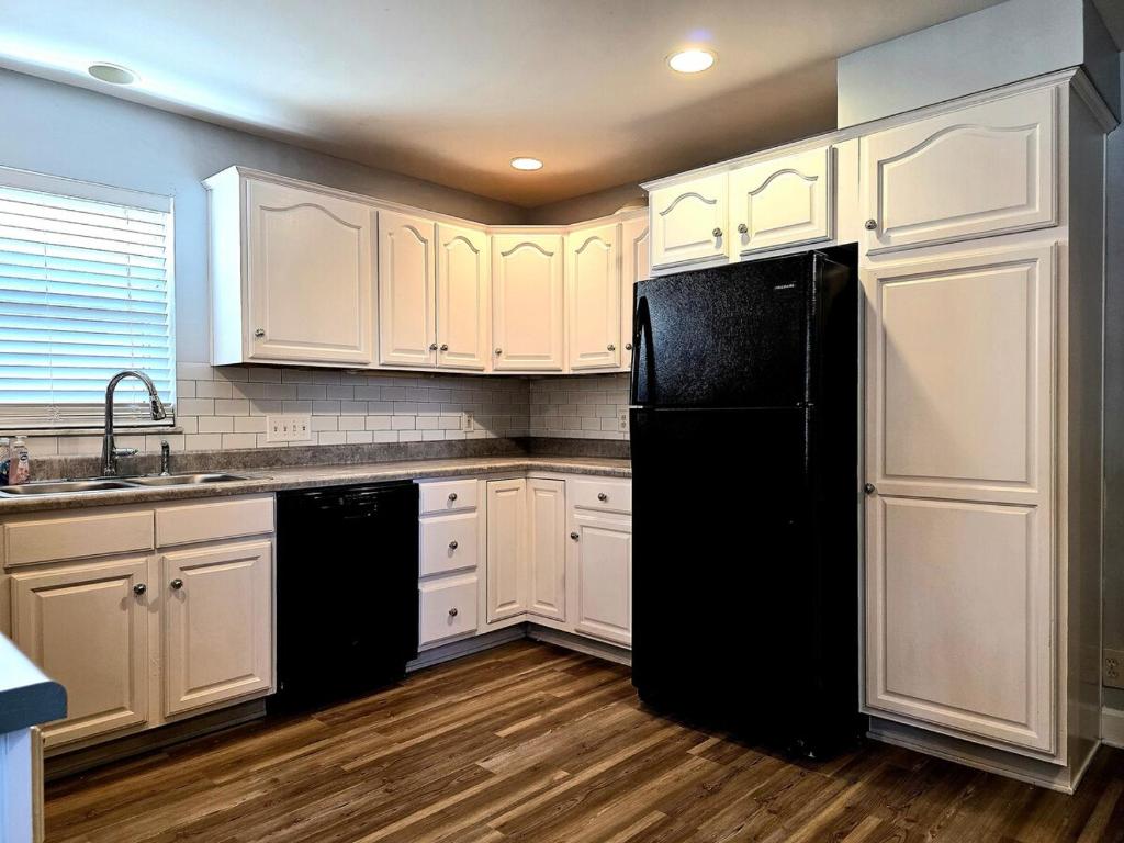 a kitchen with white cabinets and a black refrigerator at 513Company - Sanctuary in Cincinnati