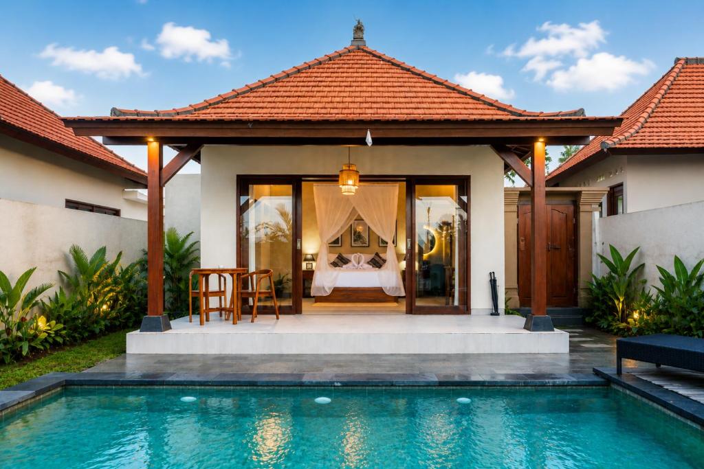 a bedroom in a villa with a swimming pool at Akar Villa in Ubud