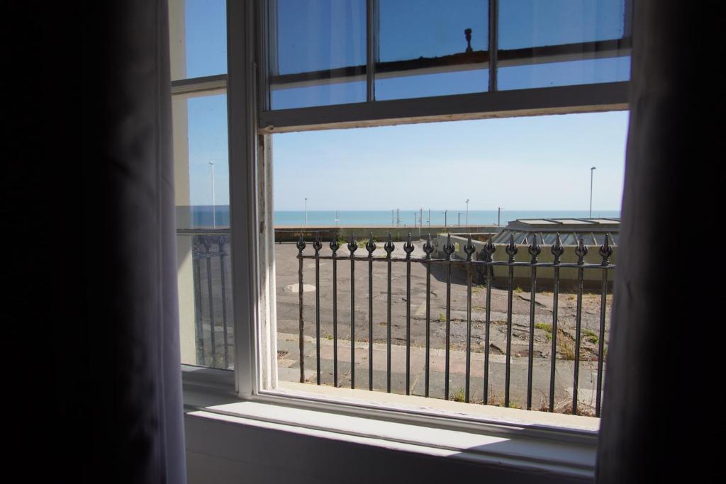 an open window with a view of the beach at Ground floor sea view flat Hastings in Hastings