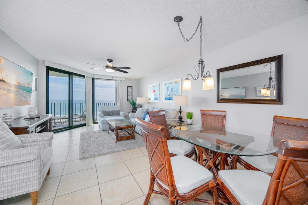 a dining room and living room with a table and chairs at Phoenix VII 7709 condo in Orange Beach