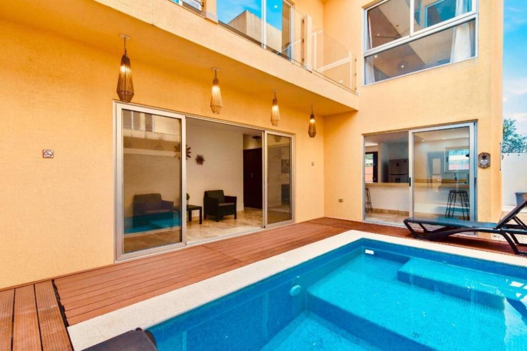 a home with a swimming pool and a house at Tulum Paradise - Private Pool & Rooftop Deck in Tulum