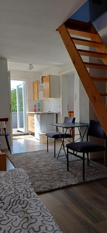 a living room with a table and a kitchen at Ferienwohnung Kirschbaumblick in Ettringen