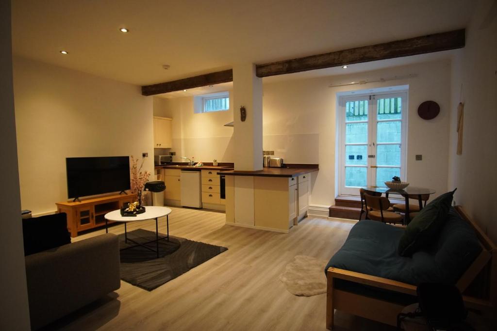 a living room with a couch and a kitchen at Garden Seafront Flat Hastings in Hastings