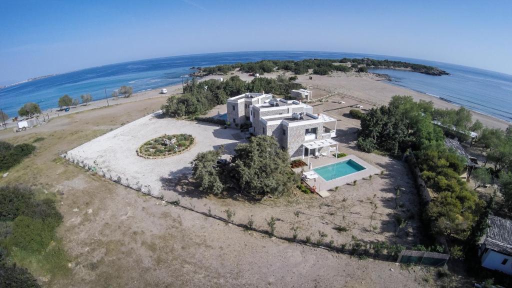 an aerial view of a large house on a beach at Cedar Bay Beachside Villas in Palaiochora