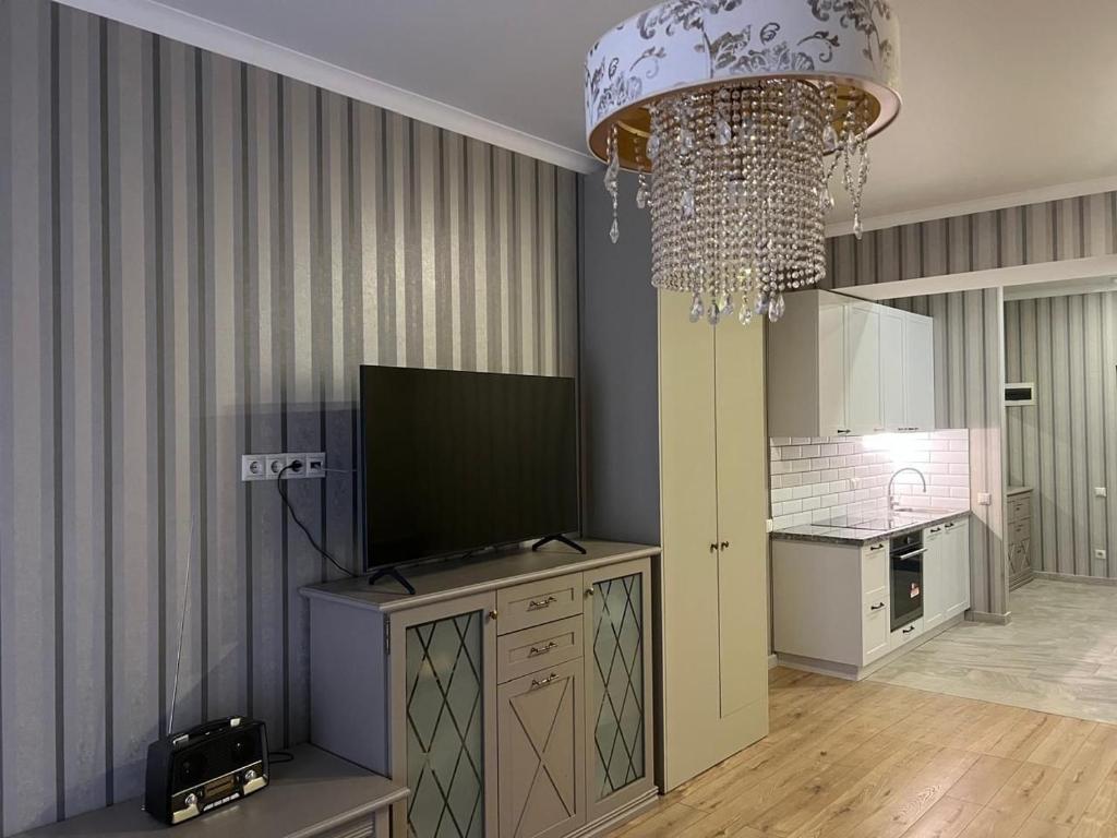 a room with a television and a chandelier at Guest Apart in Ozurgetʼi