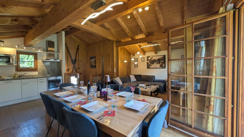 a dining room with a long table and a kitchen at Chalet Veronique Private Sauna & FREE SaastalCard in Saas-Fee