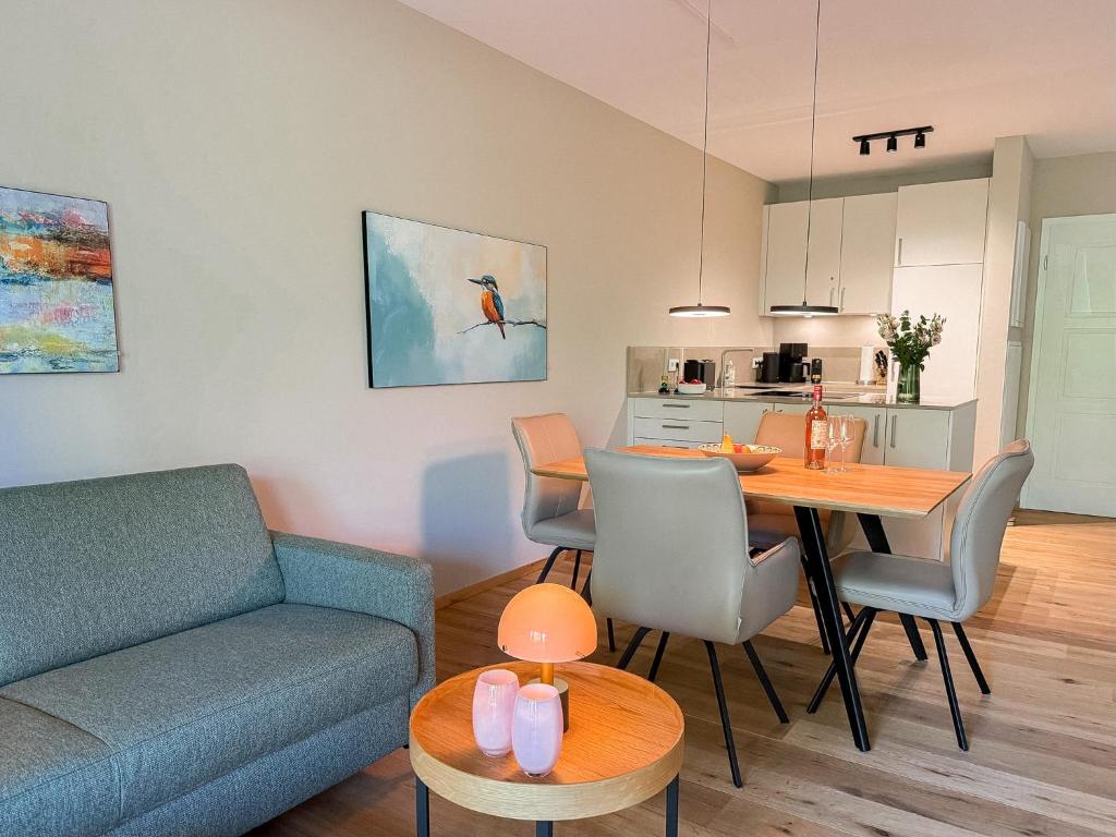 a living room with a couch and a dining room table at Ferienwohnung Lütte Bleev am Dümmer See in Lembruch
