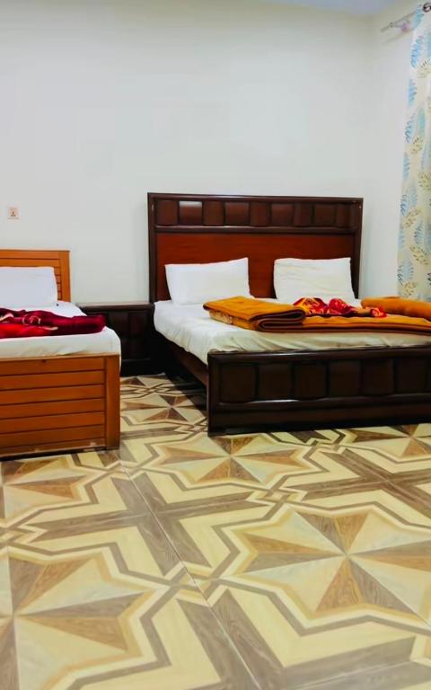 two beds sitting next to each other in a bedroom at Pine View Hotel Tranna Balakot in Taranna