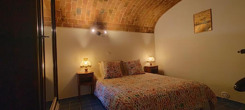 a bedroom with a bed and two lamps on two tables at Chez Dany et Alain in Brouzet-lès-Alès