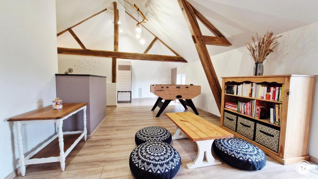 a living room with a table and a book shelf at La Virée Champêtre in Villiers-Saint-Benoît