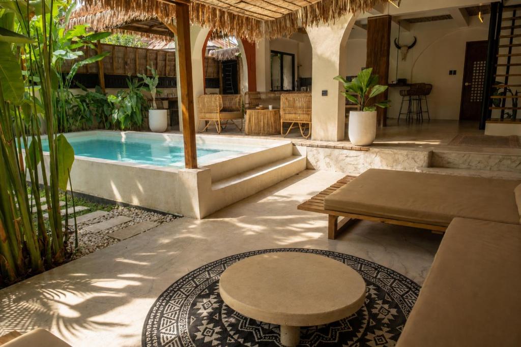 a patio with a pool with a table and a bench at DILAW Villa avec piscine privée in El Nido