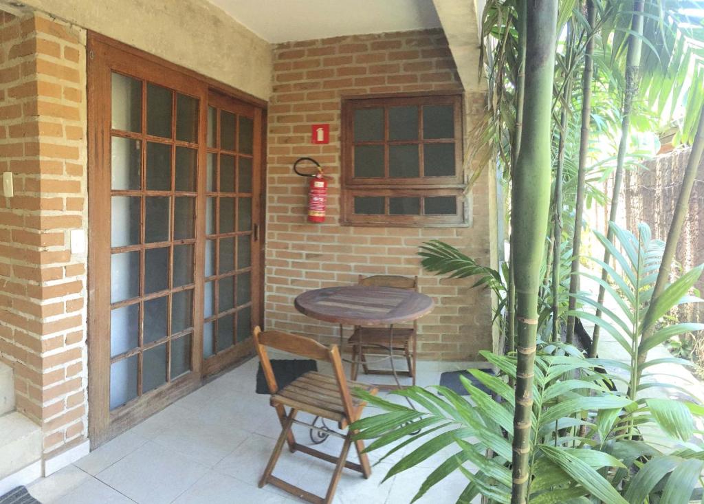 een kleine patio met een tafel en 2 stoelen bij Flats Vila Vitoria Residencial in Camburi