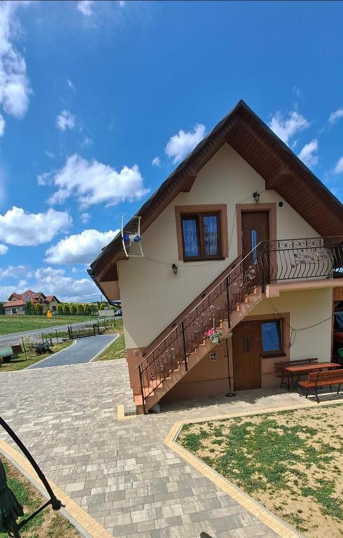 a house with a staircase in front of it at Domek Rosa in Bachlowa