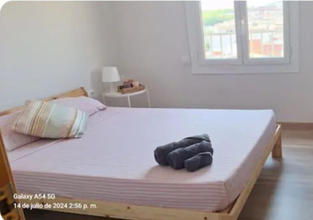 a bed with two black towels on top of it at Under the Mediterranean sky in Terrassa