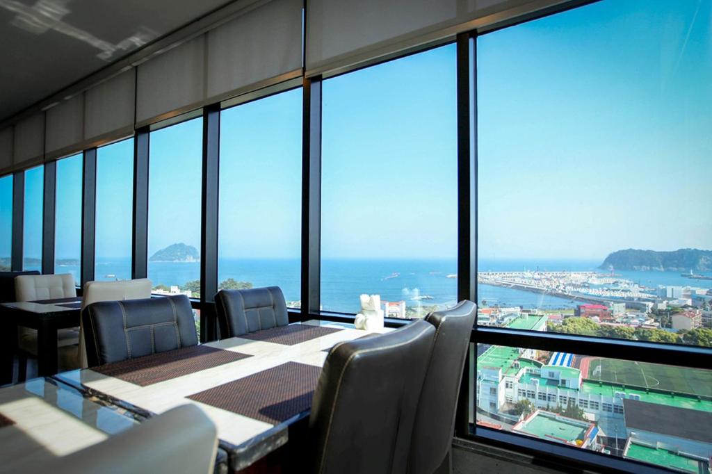 a dining room with a view of the ocean at Eins Hotel in Seogwipo