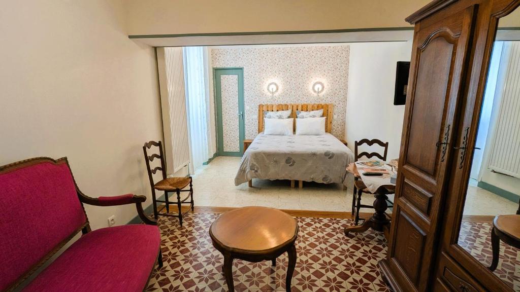 a hotel room with a bed and a couch at Les Chambres de Grangette in Thury
