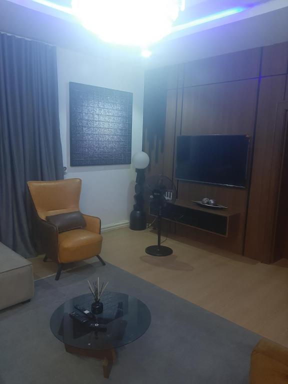 a living room with a chair and a television at Jasper luxury homes in Abuja