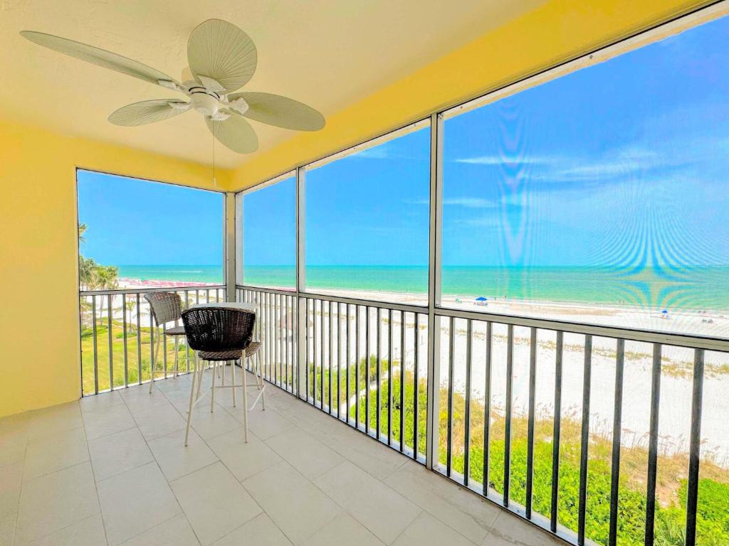a balcony with a ceiling fan and a view of the beach at Vacation Villas #432 - Beachfront Condo in Fort Myers Beach