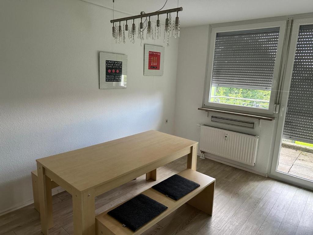 a dining room with a wooden table and two windows at Helles Apartment mit Self Check-in in Nuremberg