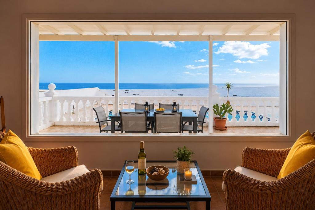 a room with a table and chairs and a large window at La Ventana al Mar in Güime