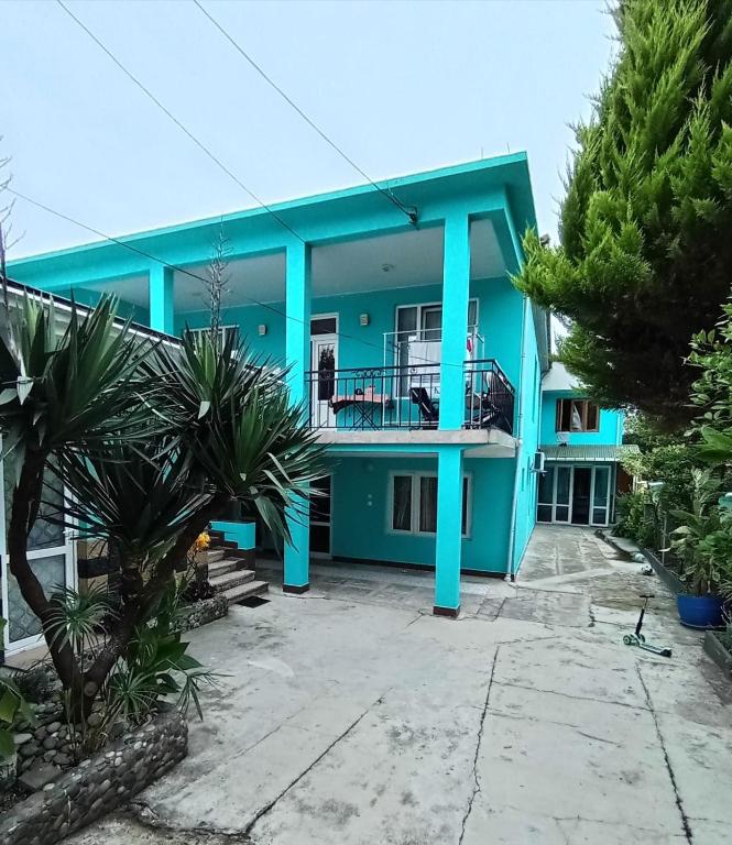 a blue house with palm trees in front of it at Andrea's hays in Kobuleti