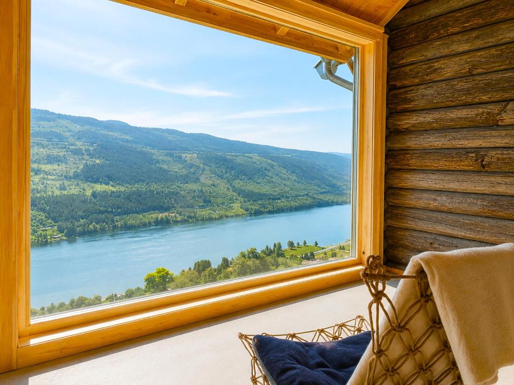 a window in a room with a view of a lake at Architect designed sleeping box in barn in Nos