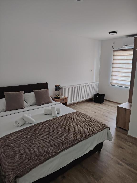 a bedroom with a large bed and a window at Apartmani Hilston in Vršac
