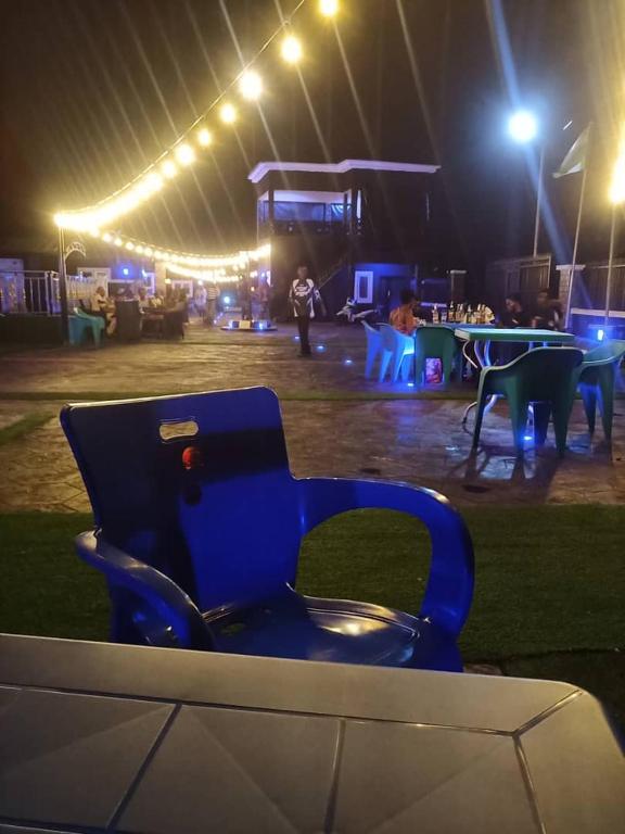 a blue chair in front of a stage at night at Villa Liga Hotels Concerpts in Erunmu