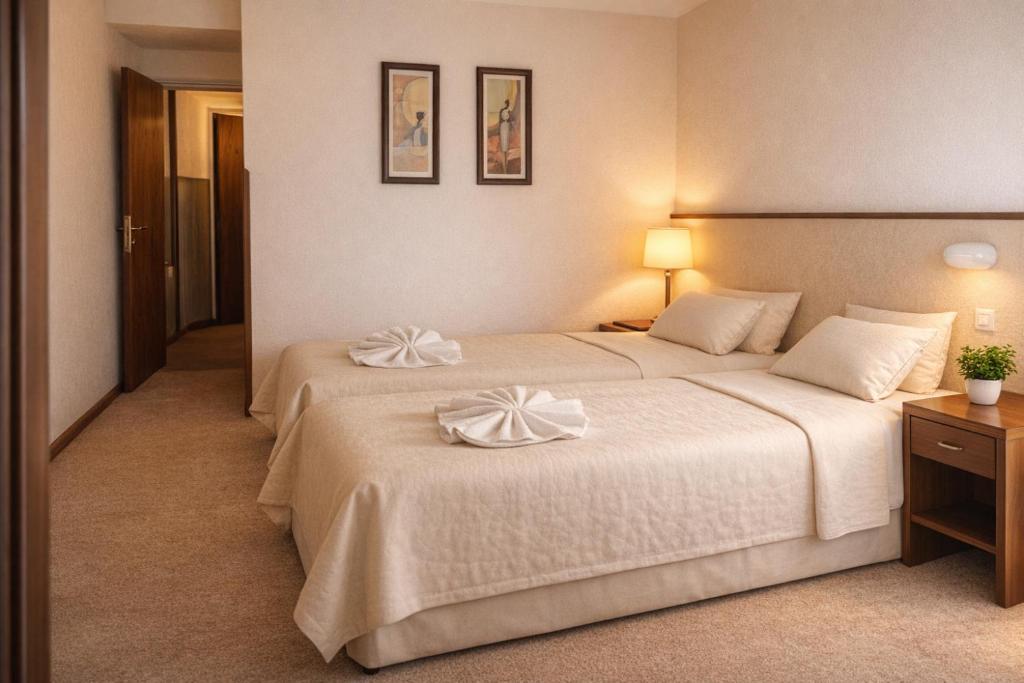 a hotel room with two beds with towels on them at Hotel Gran Lucerna in Valle Hermoso