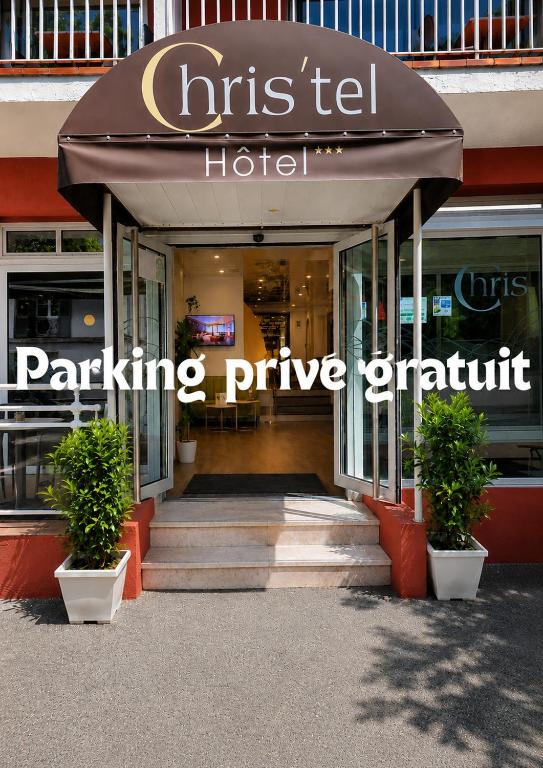 ein Gebäude mit einem Eingang zu einem Parkautomaten in der Unterkunft Cit'hôtel Le Chris'tel hôtel et restaurant in Le Puy en Velay