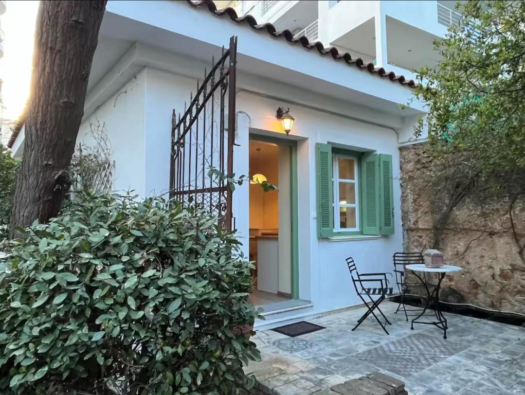 a small white house with a table and chairs at Orpheus Guesthouse in Athens