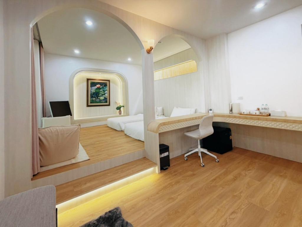 a bedroom with a bed and a desk and a mirror at Kharin guesthouse in Nakhon Phanom