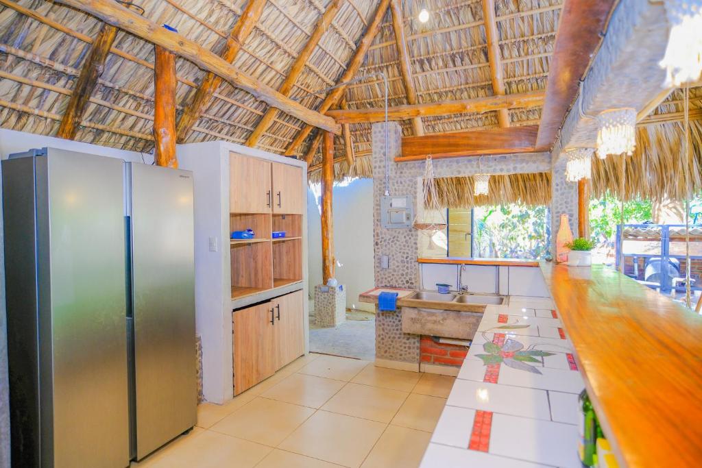 a kitchen with stainless steel appliances and a wooden ceiling at Las Golondrinas KM59 in Taquillo